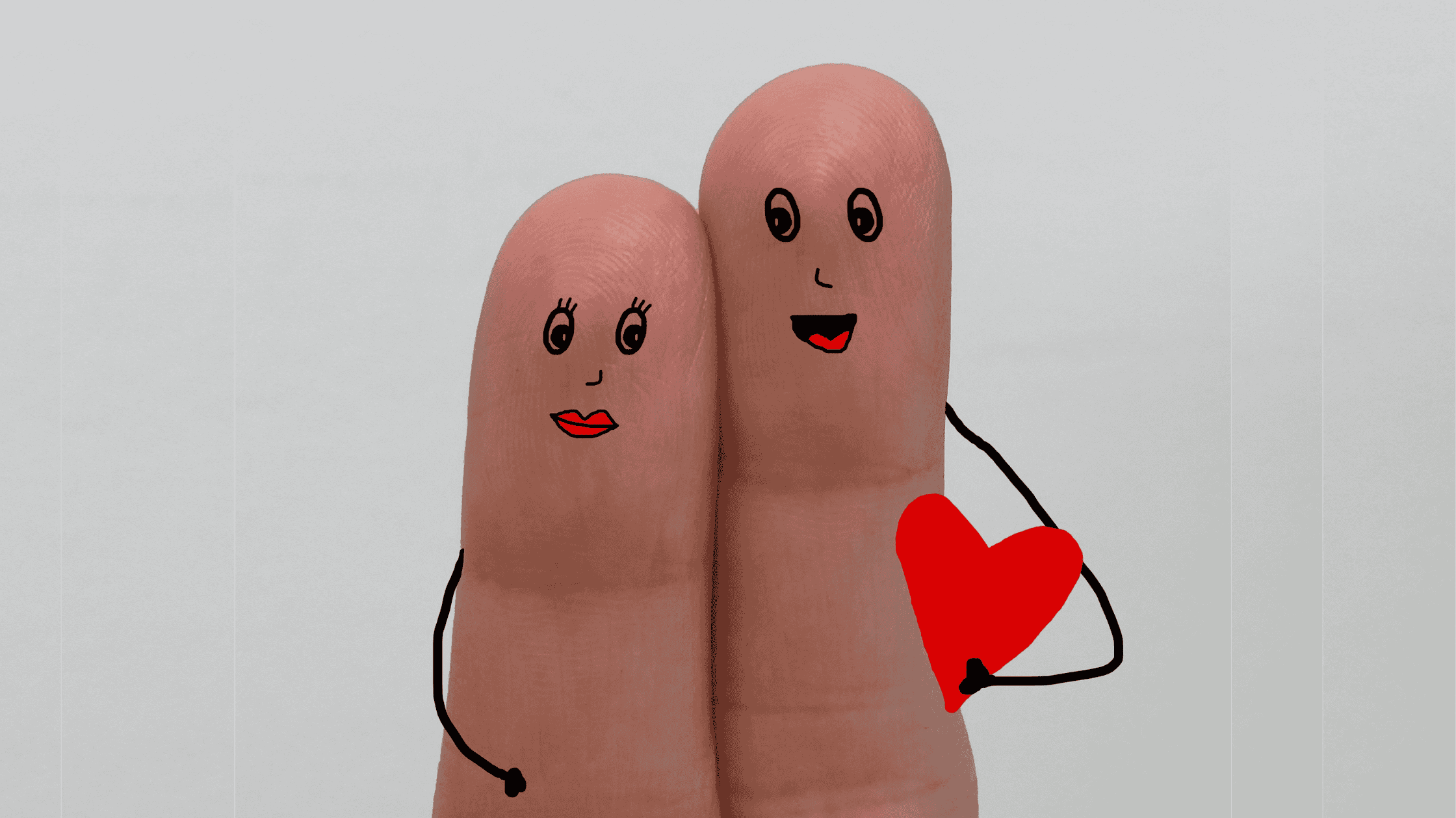 Fingerpaar mit gezeichneten Gesichtern und Herz – symbolisches Bild für liebevolle Jahrestag-Geschenke von Surprisa