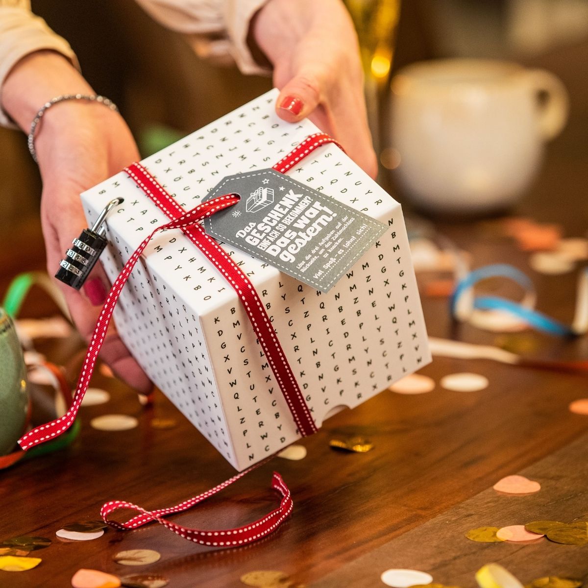 Weisse Buchstaben-Rätselbox wird ausgepackt – spannendes Geldgeschenk von Surprisa