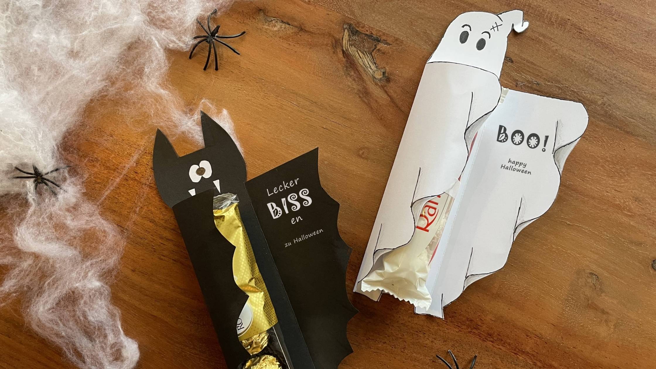 Halloween-Bastelidee mit Papiergespenst und Fledermaus, die Schokosüßigkeiten halten – süß statt gruselig